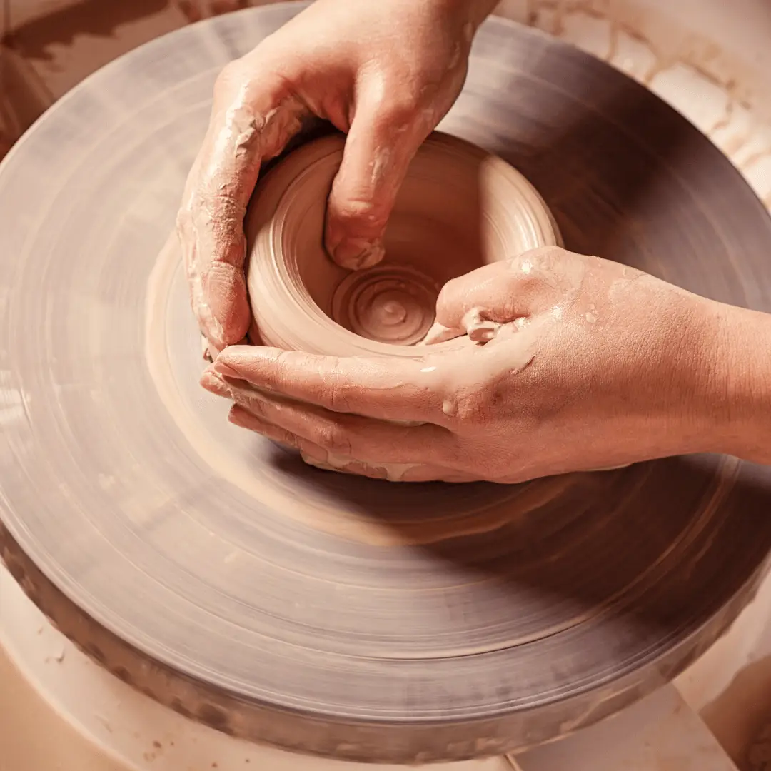 A clay sculpture of a person's hands molding a heart-shaped object, symbolizing healing through art.
