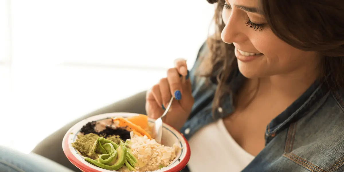 A woman enjoying a bowl of vegan food, promoting a healthy lifestyle.