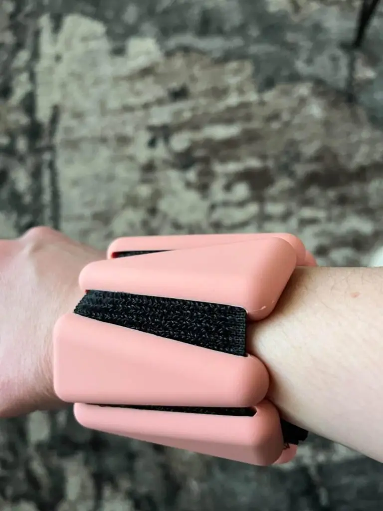 A wristband with pink and black straps.
