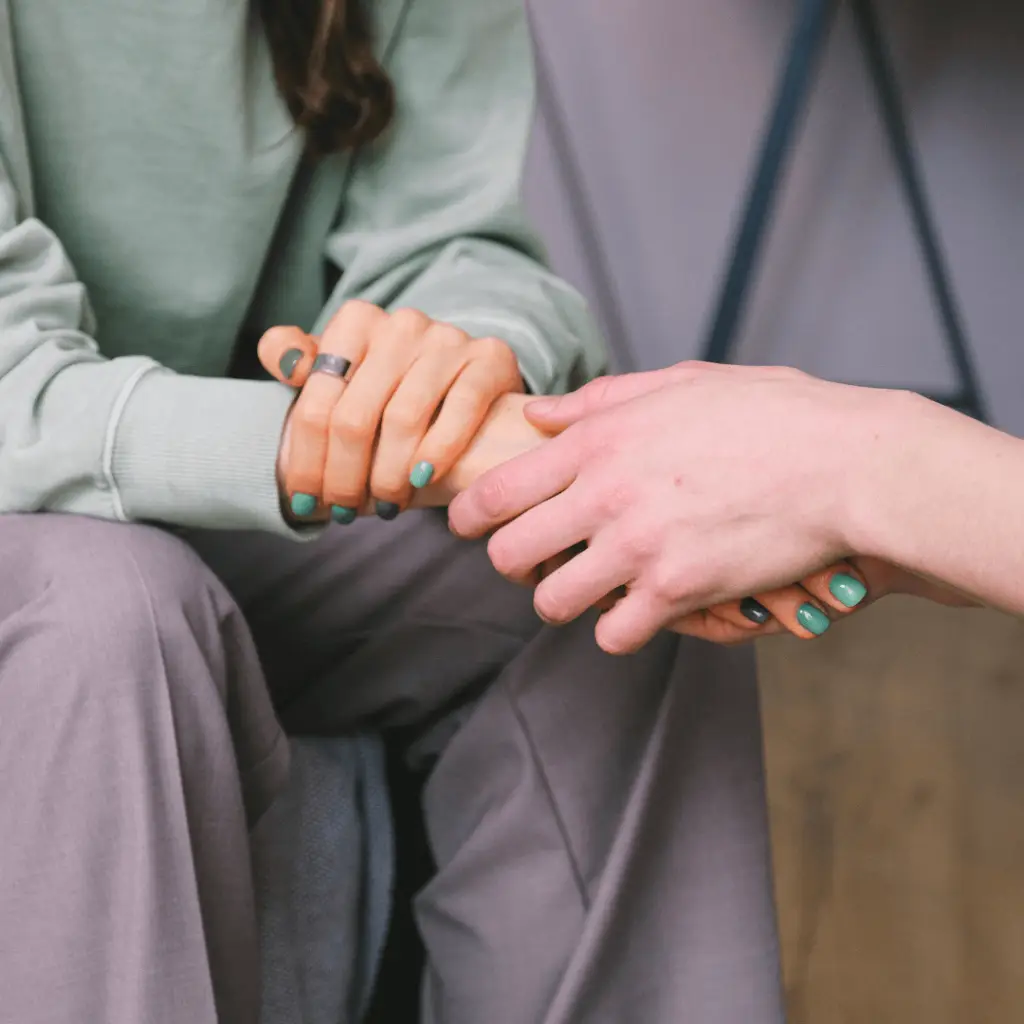 A supportive community for women with Polycystic ovary syndrome, depicted by two women holding hands.