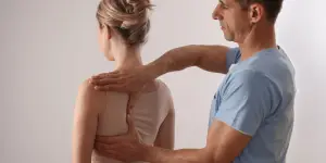 Posture correction session with man assisting woman in physical therapy.