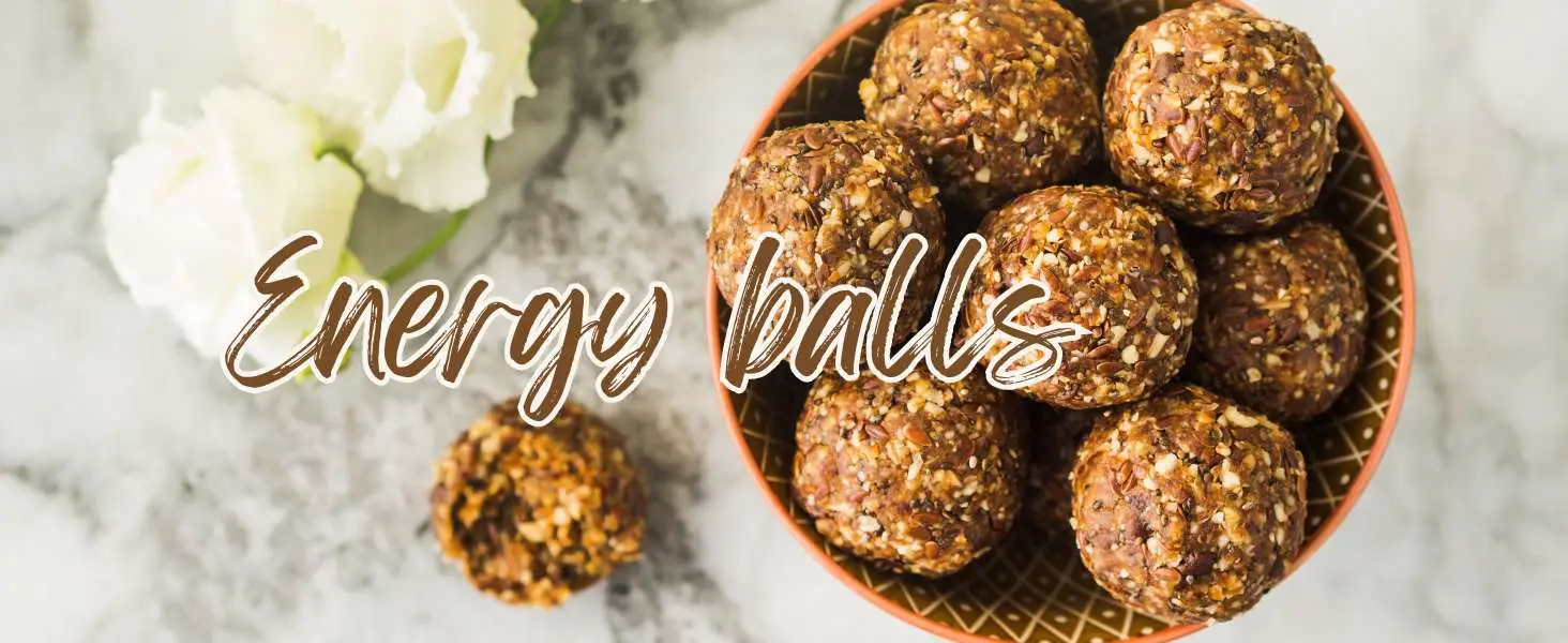 Bowl of energy balls with flowers, healthy snack option.