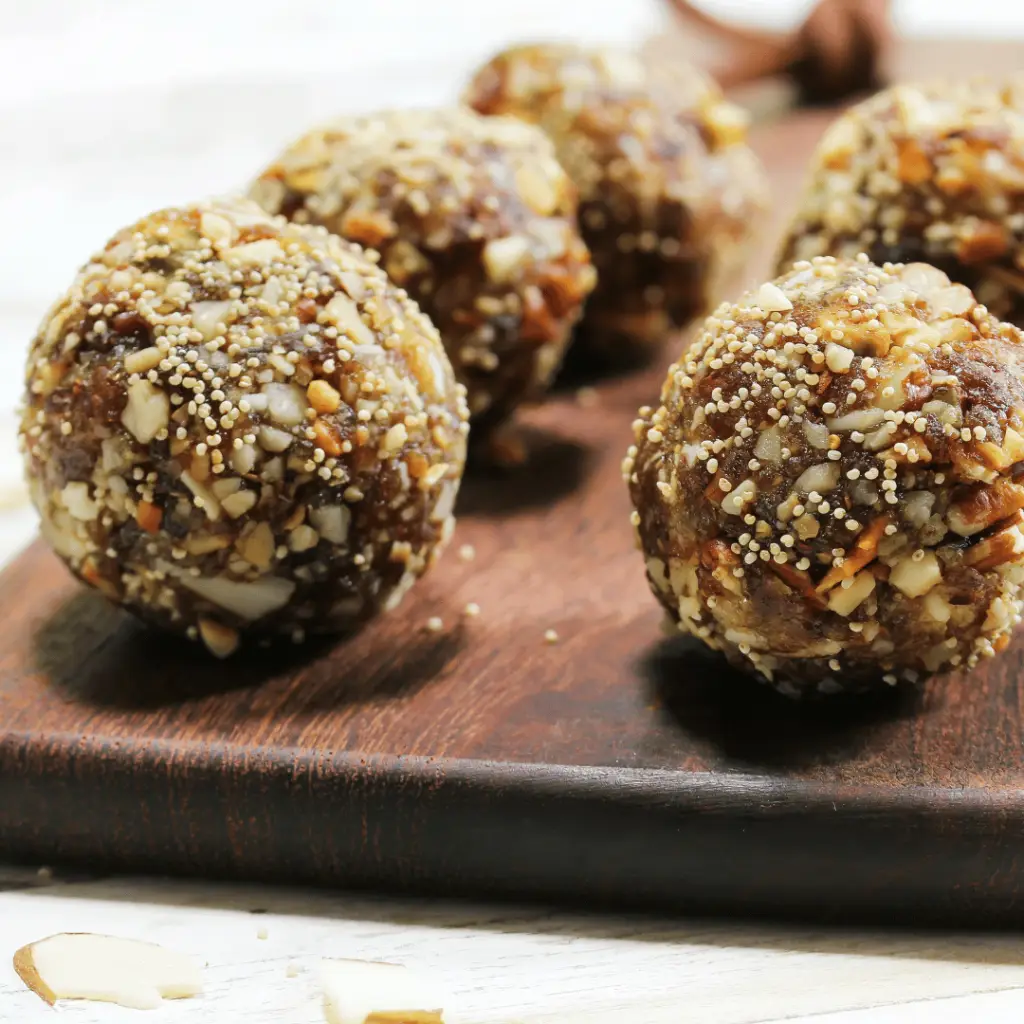 A wooden cutting board with a energy balls.