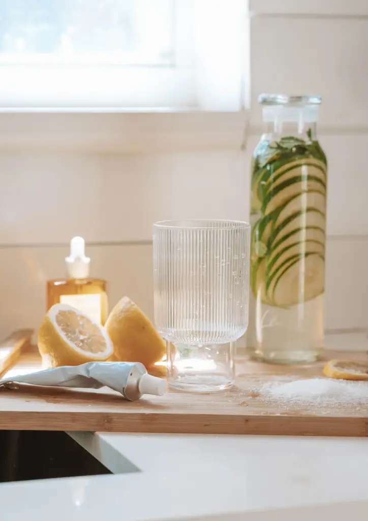 A kitchen counter with a glass of water, lemon slices, and a knife. Hydration for menopause.