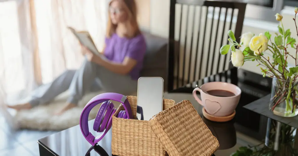 Woman on couch reading book, embracing digital detox.