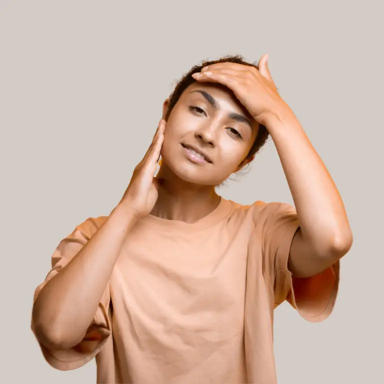 A woman practicing facial yoga, gently touching her face with her hands to enhance relaxation and rejuvenation.
