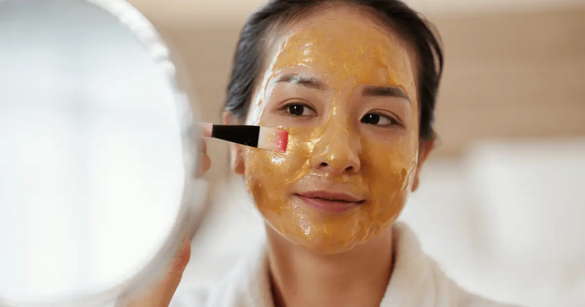 A woman applies a honey mask to her face, showcasing a DIY beauty hack for glowing skin.