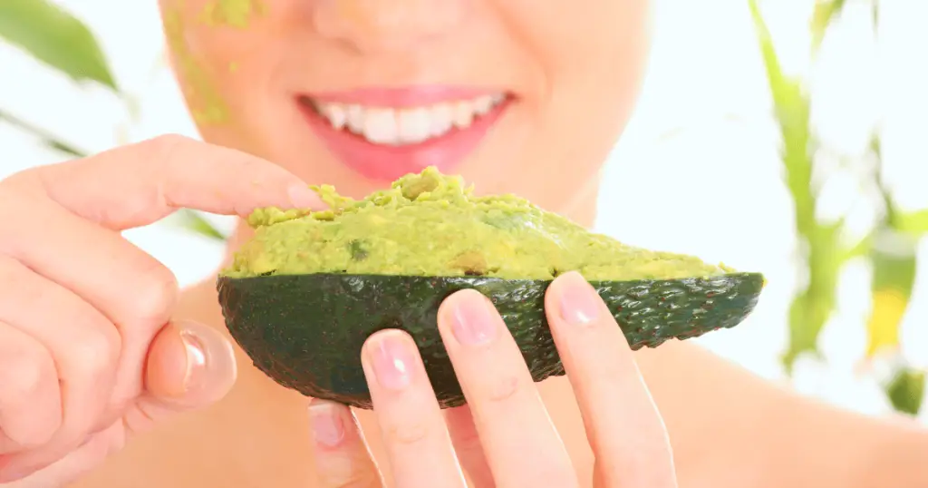A woman holds an avocado in her hand, showcasing its use in DIY beauty hacks with oatmeal.