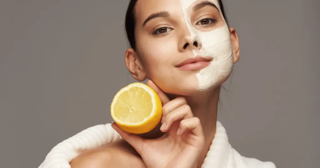 A woman wearing a face mask holds a lemon, showcasing a DIY beauty hack with lemon and yogurt for skincare.