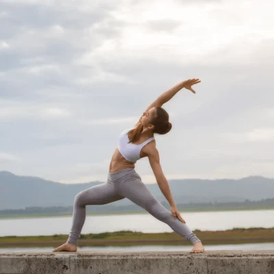 Female practicing yoga on concrete wall, focusing on higher self during exercises.